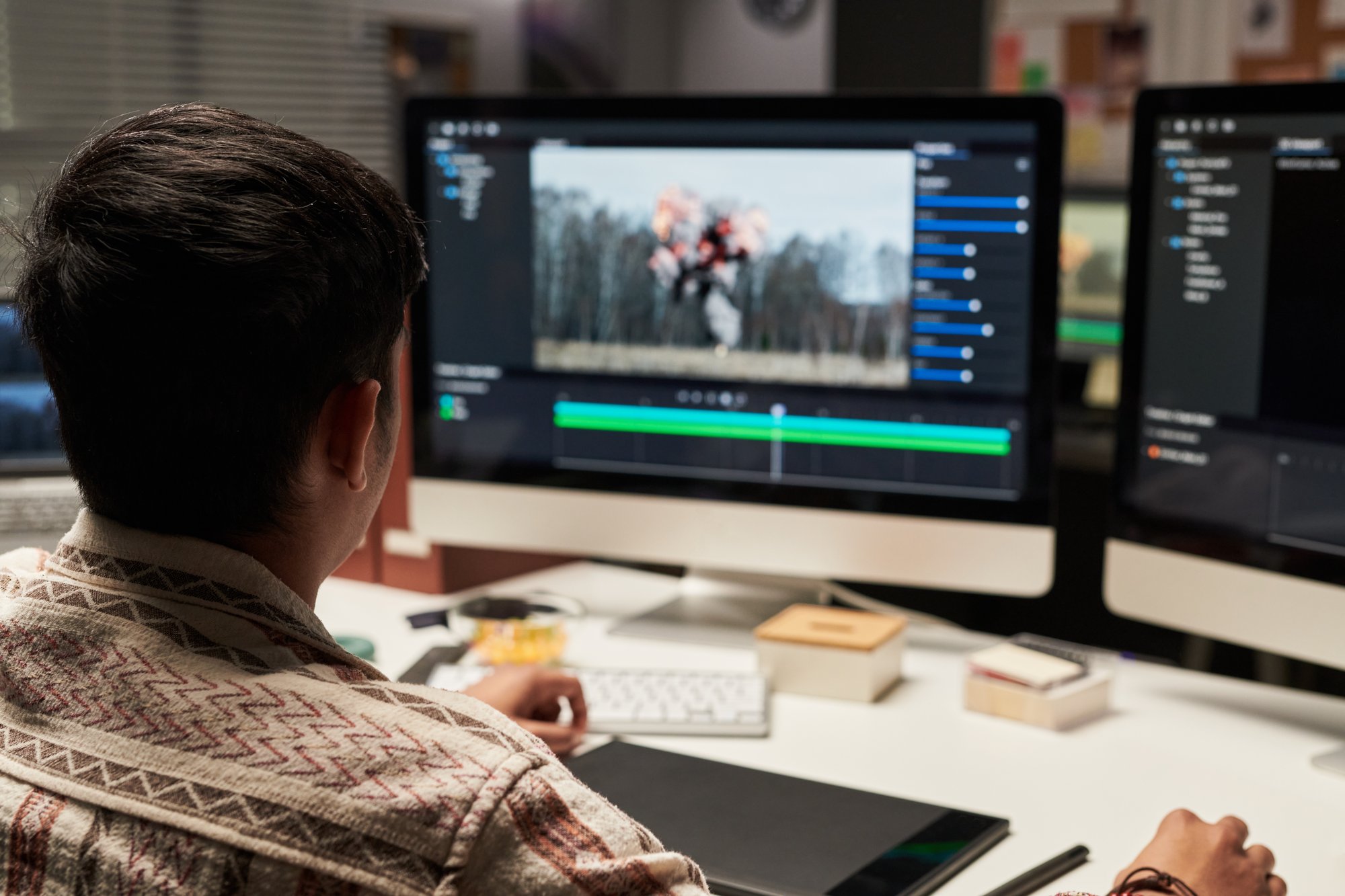 Person is sitting at a desk looking at VFX editing software on a computer monitor