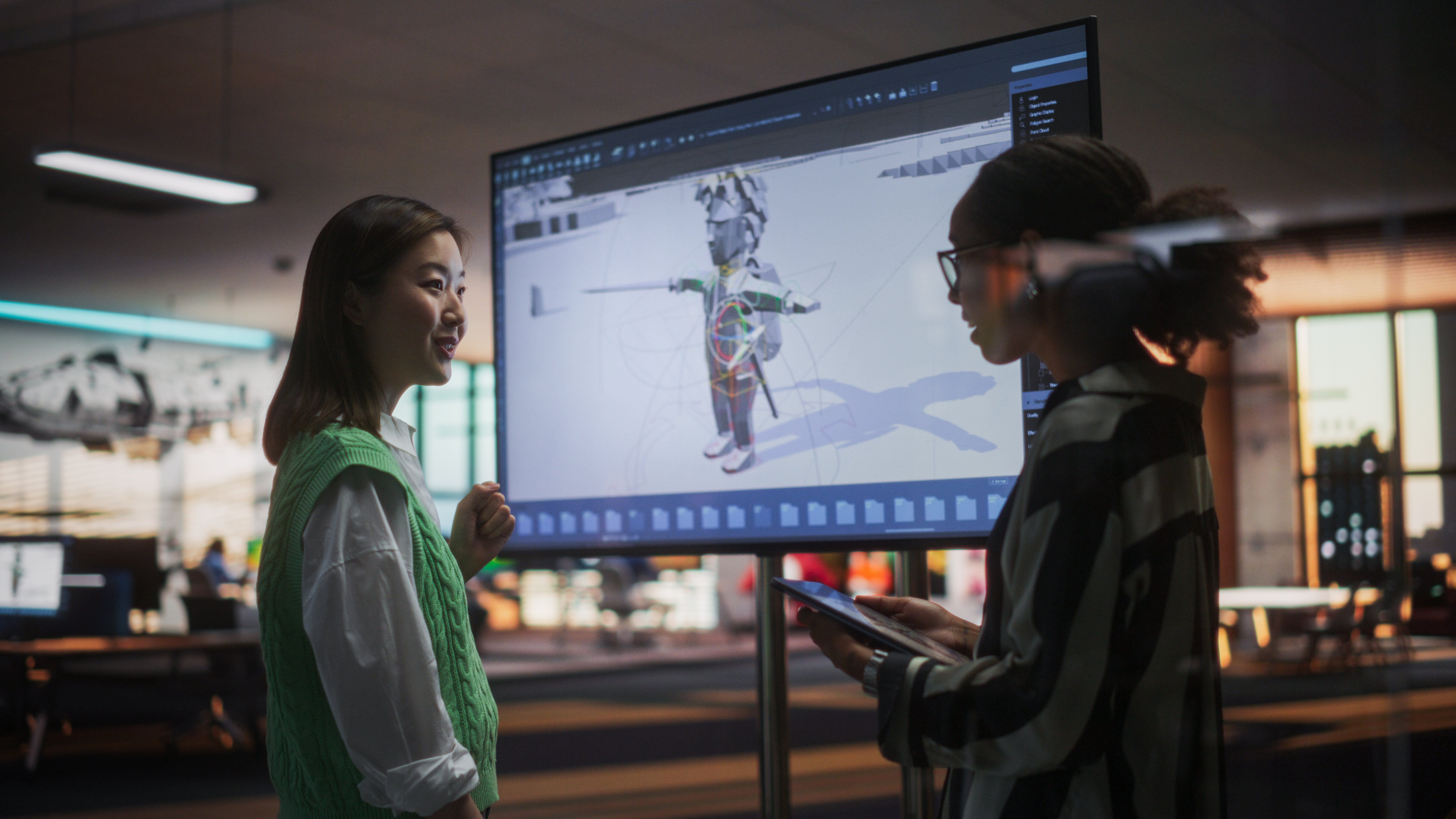 Two workers looking at 3D modelling software in a creative studio