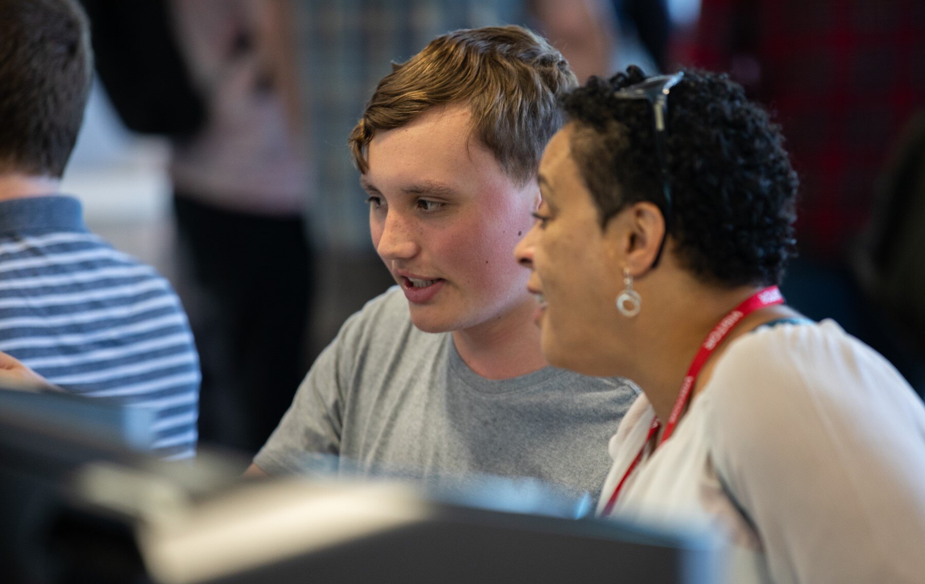 Student showing work on a computer screen to industry